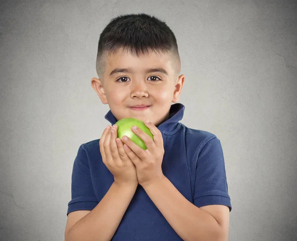 Happy child boy eating green apple
