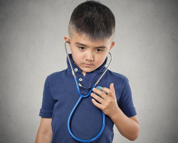 Child little boy listening to his heart with stethoscope