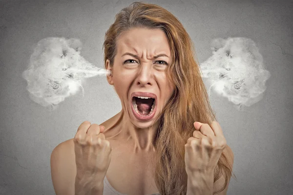 Angry young woman blowing steam coming out of ears