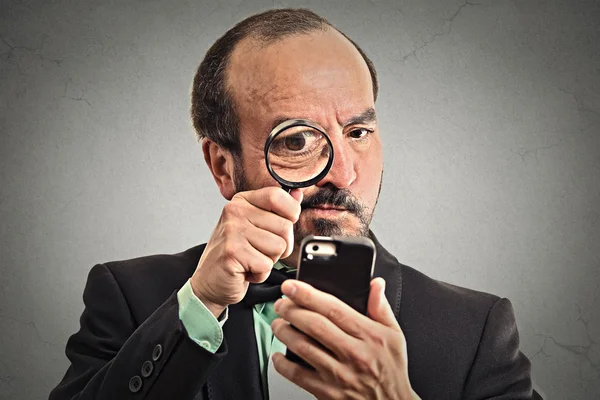 Man looking through a magnifying glass on smartphone