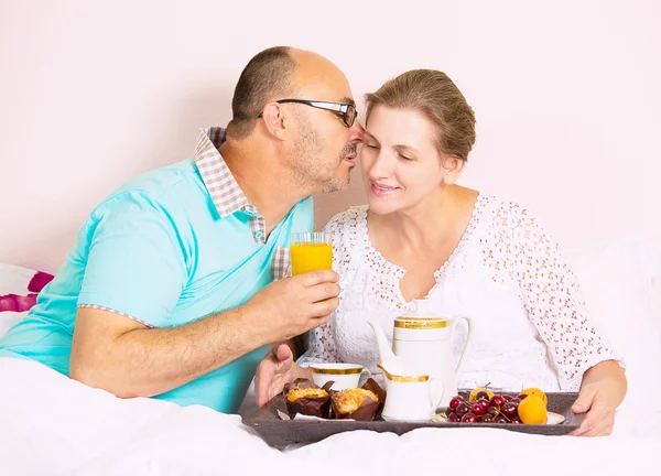 Couple having breakfast in bed