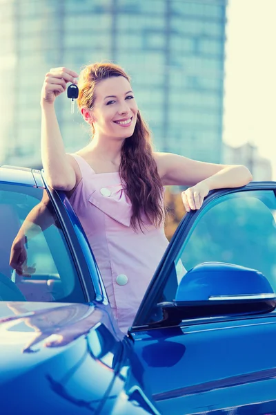 Woman showing keys of new car