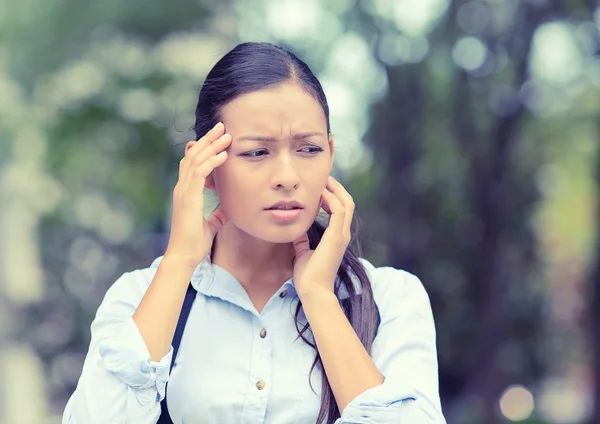 Unhappy woman stressed having headache isolated outside background