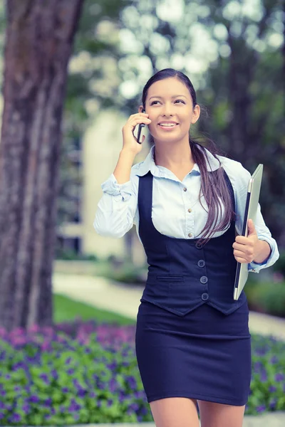 Successful businesswoman young entrepreneur talking on cellphone while walking outdoor