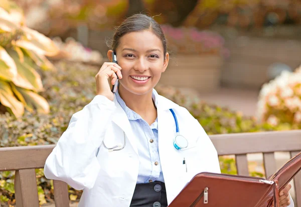 Smiling confident female doctor healthcare professional talking on phone