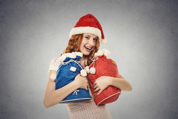 santa helper in red hat holding gift sacks