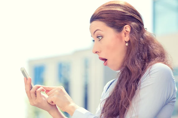 Anxious young girl looking at phone seeing bad news or photos with disgusting emotion