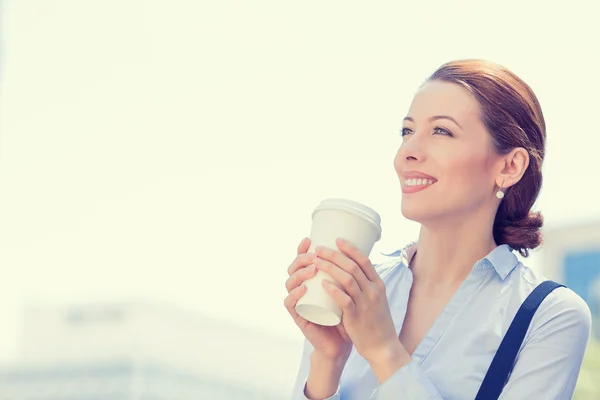 Woman drinking coffee in sun standing outdoor