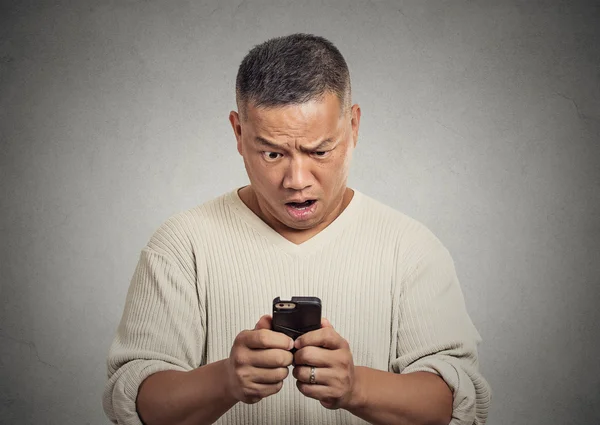 Surprised shocked pissed off man unhappy by what he sees on cellular phone