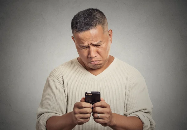 Sad upset middle aged man seeing bad news email text on cellphone