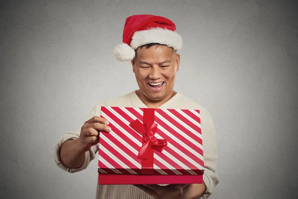 Excited surprised middle aged man opening unwrapping red gift box