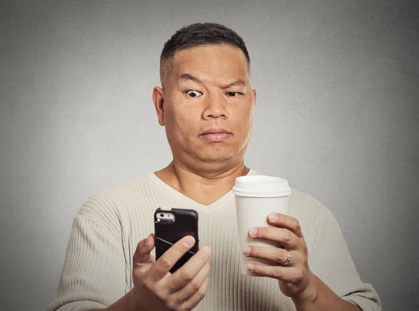 Worried skeptical surprised man reading bad news sms on smartphone