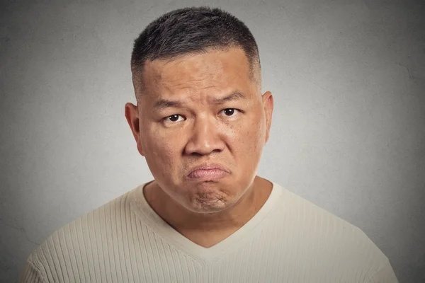 Grumpy man isolated on grey wall background