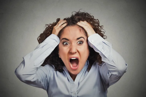Frustrated shocked business woman pulling hair out yelling
