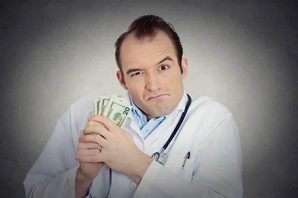 Grumpy greedy miserly health care professional holding money