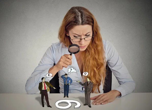 Businesswoman skeptically looking at arguing people through magnifying glass