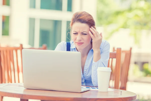 Stressed displeased worried business woman sitting in front of laptop computer