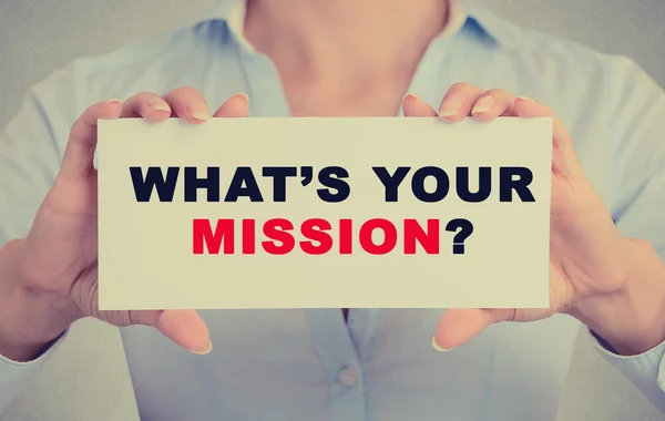 Businesswoman hands holding sign with what's your mission question