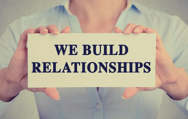 Businesswoman hands holding card with we build relationships message
