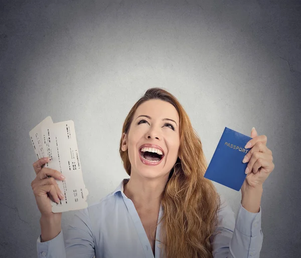 Excited tourist woman holding passport flight ticket