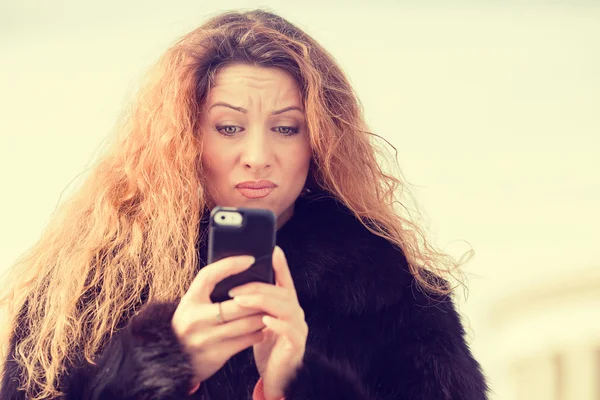 Upset skeptical unhappy woman talking texting on mobile phone