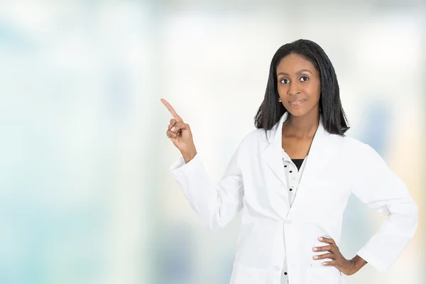 Female doctor medical professional pointing finger at copy space