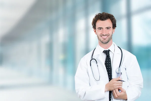 Doctor smiling standing in hospital hallway clinic