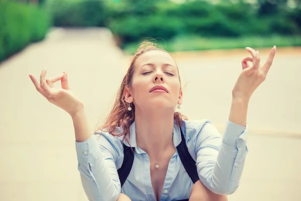 Business woman eyes closed hands raised in air relaxing meditating