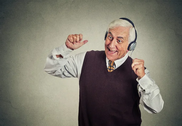 Elderly man with headphones listening to radio enjoying music