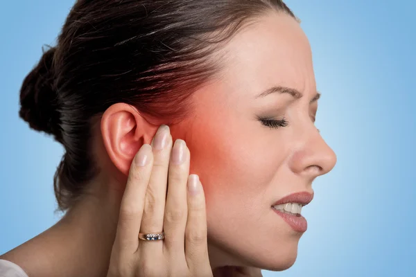 Sick female having ear pain touching her painful head