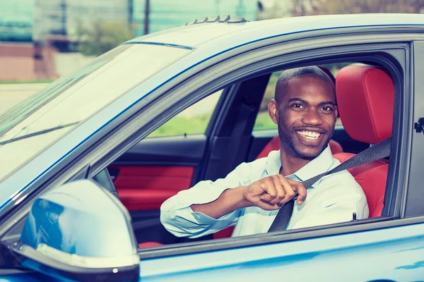 Car driver young man wearing safety belt driving new car