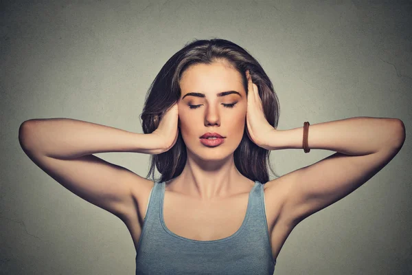 Attractive casual woman covering with hands her ears