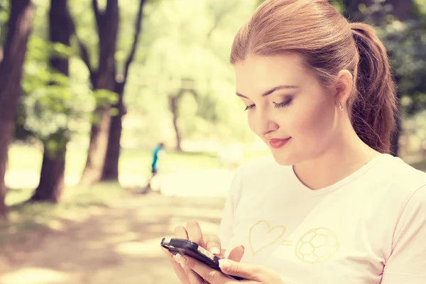 Happy, cheerful, young woman excited by what she sees on cell phone texting