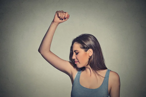 Woman, smelling, sniffing her wet armpit, something stinks