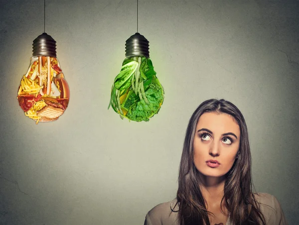 Beautiful woman thinking looking up making diet choice