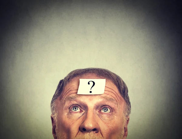 Thinking man with question mark on gray wall background