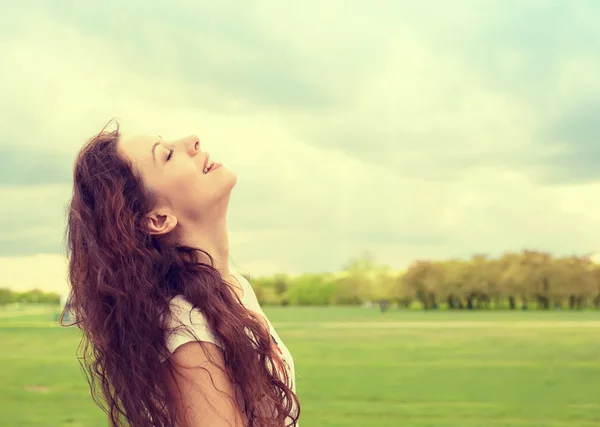 woman smiling looking up to blue sky celebrating enjoying freedom