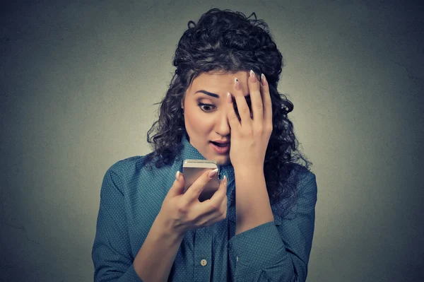 Anxious scared young girl looking at phone seeing bad news photos message
