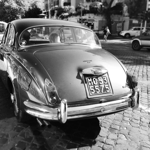 Back view of Jaguar car, black and white