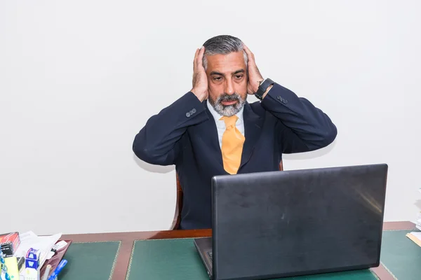 Desperate businessman. in front of the desk with the computer, it panic, depression.