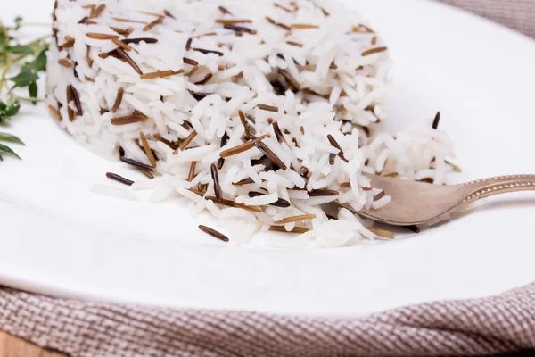 Mixed cooked rice with thyme on white plate