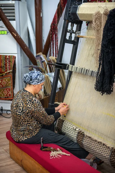 CAPPADOCIA - MAY 17 : Woman working at the manufacture of carpet