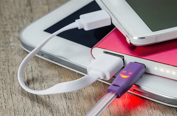 Smart Phone Charging with power bank  on the Wooden Table