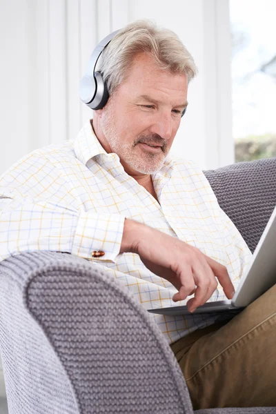 Mature Man Streams Music From Laptop To Wireless Headphones