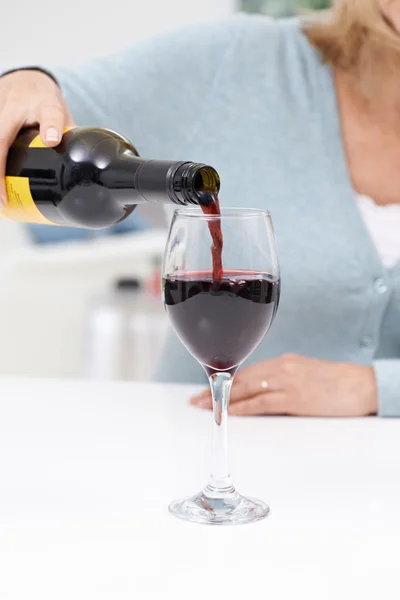 Close Up Of Woman Pouring Large Glass Of Red Wine