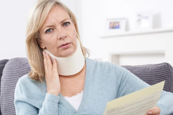Mature Woman Reading Letter After Receiving Neck Injury