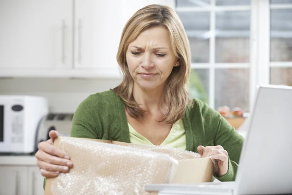 Disappointed Woman Unpacking Online Purchase At Home