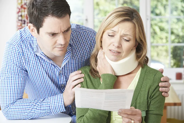 Couple Reading Letter In Respect Of Wife\'s Neck Injury