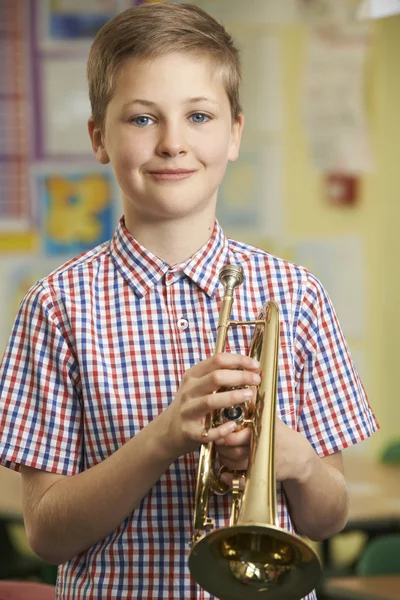 Boy Learning To Play Trumpet In School Music Lesson