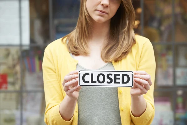 Close Up Of Shop Owner Holding Closed Sign
